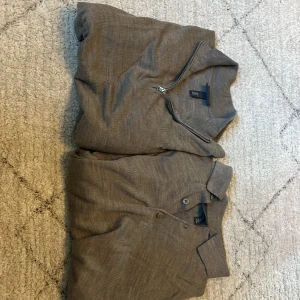 Grå långärmad tröja med dragkedja och pikétröja från H&M - Två stilrena grå tröjor från H&M i slim fit-modell. Ena tröjan har halv dragkedja vid kragen och den andra är en klassisk pikétröja med knappar. Båda är långärmade och passar perfekt till vardagslooken.