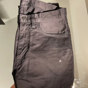 Svarta jeansbyxor från Acne Studios - Säljer ett par svarta jeansbyxor från Acne Studios. Klassisk femficksmodell med normal passform och dragkedja. Snygga och stilrena, perfekta till många olika outfits.