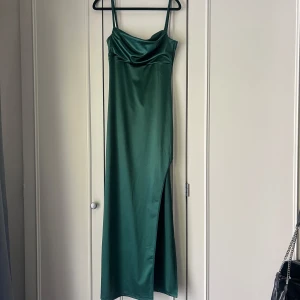 Grön balklänning  - Säljer min helt oanvända mörk gröna balklänning. Köpt i Mexiko så finns ingen exakt sån i Sverige!! Storlek S. Öppen rygg, slits vid ena benet och fin detalj vid brösten. Passar någon som är 168 o under. 