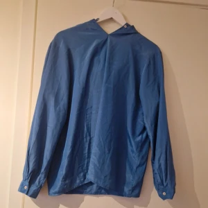 Blå långärmad skjorta med knappar - Säljer en stilren blå skjorta med lång ärm och knappar vid ärmsluten. Skjortan har en klassisk passform och är perfekt för dig som gillar enkel och clean stil. Passar lika bra till jeans som till chinos.