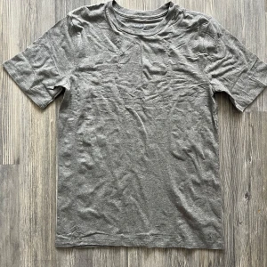 Grå t-shirt från Polo Ralph Lauren - En klassisk grå t-shirt från Polo Ralph Lauren. T-shirten har rund halsringning och korta ärmar. Tillverkad i mjuk bomull, perfekt för en avslappnad stil. Aldrig använd pga storleken. Köp alla tre i min profil för 450:-🫰