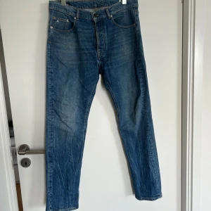 Blå raka jeans - Klassiska blå jeans med raka ben och fem fickor. Jeansen har normal passform och är tillverkade i denim med lätt slitning på framsidan och baksidan. Perfekta för en avslappnad stil.
