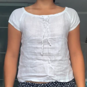Vit kortärmad blus från Hennes Collection - Säljer en söt vit blus från Hennes Collection i storlek 38. Blusen är kortärmad och har en knytning framtill. Perfekt för sommardagar eller en avslappnad look. Den är i bra skick och väldigt bekväm att ha på sig. Passar bra till både jeans och kjol!