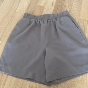 Beige shorts från Pieces - Ett par beige shorts från Pieces i storlek XS. Shortsen har en elastisk midja och är tillverkade i ett mjukt och bekvämt material.