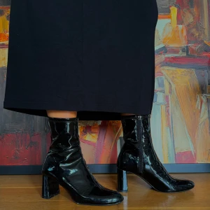 Svarta lackstövletter med klack - Säljer ett par snygga svarta lackstövletter med klack. De har en glansig finish och dragkedja framtill för enkel på- och avtagning. Perfekta för höst och vinter! Stövletterna har en spetsig tå och är i nyskick. Passar perfekt till en chic outfit!