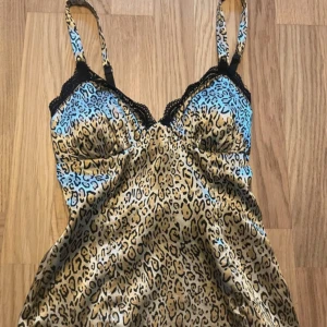 Leopardmönstrad topp från Guess - Säljer en snygg leopardmönstrad topp från Guess i storlek XS. Toppen har smala axelband och är tillverkad i ett stretchigt material som känns bekvämt mot huden. Perfekt för en utekväll eller fest! 🐆✨