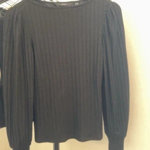 Svart ribbad tröja från Vero Moda - Säljer en snygg svart ribbad tröja från Vero Moda. Tröjan har långa ärmar och är perfekt för både höst och vinter. Den är i storlek XS och är i mycket bra skick. Perfekt för en stilren och enkel look!