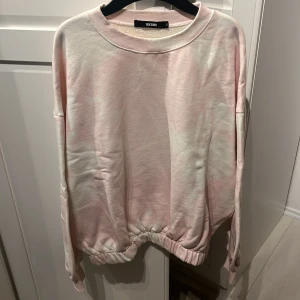 Vit/rosa sweatshirt  - Vit/rosa sweatshirt i storlek S från Bik Bok. Gul ”fläck” längst ned, går förmodligen att tvätta bort. 