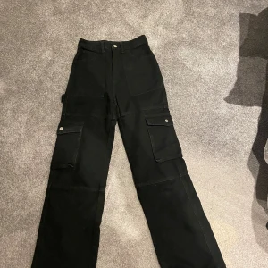 Vida/raka jeans med fickor svart - Ett par svarta jeans med fela fickor. Lite vida/raka. Använda en gång. Går inte att få bild med jeansen på då dem är för små. 