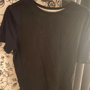Svart t-shirt - Säljer en enkel och stilren svart t-shirt. Perfekt för vardagsbruk eller som basplagg i garderoben. T-shirten är i bra skick och har korta ärmar. Passar till allt och är superbekväm!