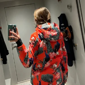 Orange skidjacka med mönster - Ornage skidjacka från MOLO med mönster påfåglar 🦚och blommor 🌸  I storlek 164  Pris kan diskutera
