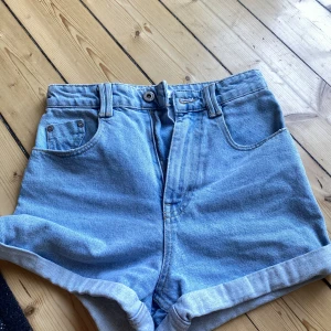 Blå jeansshorts från Zara - Säljer ett par snygga blå jeansshorts från Zara i storlek XS. De är högmidjade och har en klassisk femficksdesign med uppvikta ben. Perfekta för sommaren och kan matchas med nästan vad som helst! 🩳💙