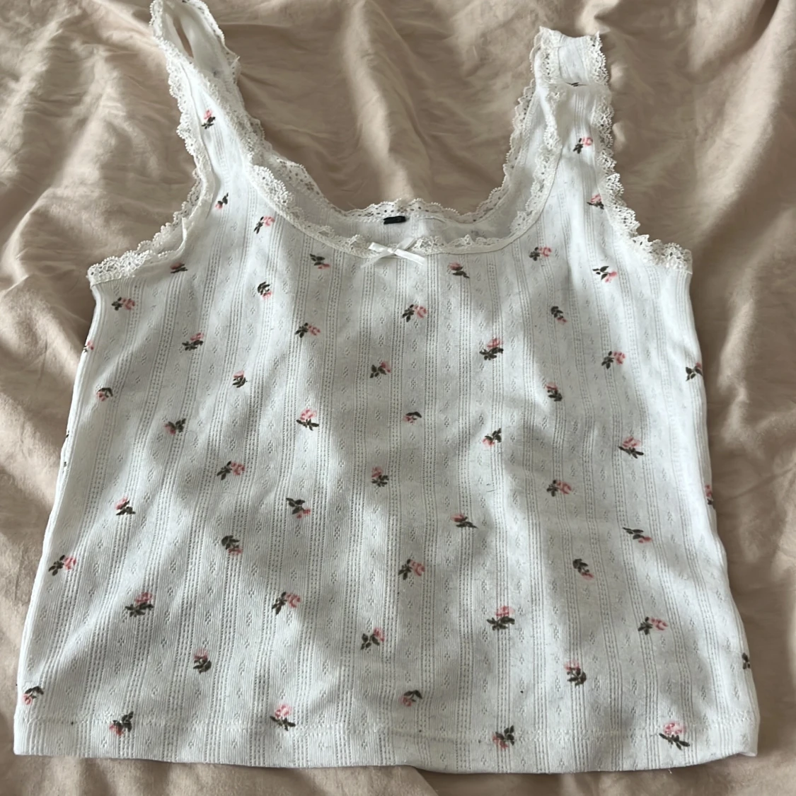 Vit blommig linnetopp med spetsdetaljer