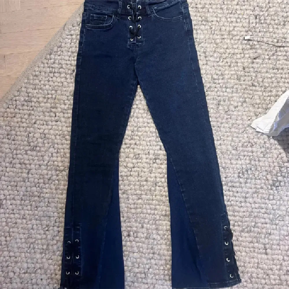 Jättefina utsvängda mörkblå jeans med snörning både nertill och upptill, Innebenslängden är 64cm o midjemåttet rakt över 31cm💓. Jeans & Byxor.