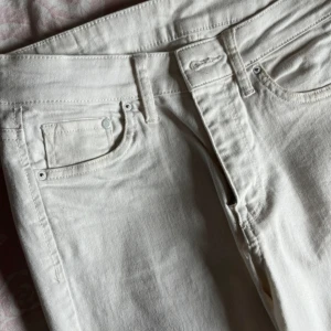 Vita skinny jeans från &Denim - Ett par vita skinny jeans från &Denim i storlek 27. Byxorna har en regular waist