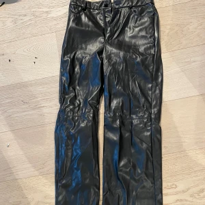 Läderbyxor - Någon slags plastläder, ganska långa i benen (är 172). Straightleg, highwaist. Sömnen i rumpan ser ut som att den är påväg att gå upp men kan nog användas en del gånger innan det händer, men därav det låga priset 