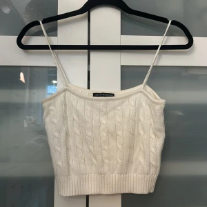 Vit stickad topp - En jättefin topp från Brandy Melville!! Säljer då jag inte använt den. Det är 100% bomull🙌🏼