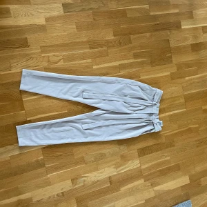 Kostymbyxor - Kostymbyxor med ”band” runt som går att knyta i fram. Byxorna är i nyskick och har knappt använts.