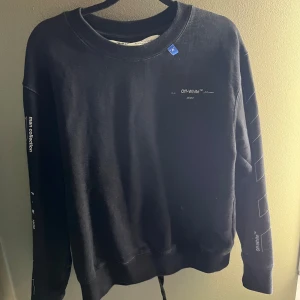Off White sweatshirt strl XS - Svart sweatshirt med vita detaljer. Tryck på fram och baksida. På ärmarna står det "Off-White™" och "main collection".  Köpt på Hypstein i Stockholm år 2020. Tyvärr inget kvitto kvar. Size XS.   Finns i Vallentuna. Köpare står för frakt. 