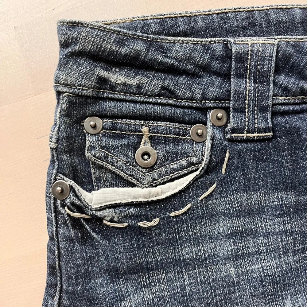 Suoercool jeanskjol med snygga detaljer. Den ahr en snygg ficka på framsidan, vita stora sömmar vid fickorna och söta stenar på fickorna i et gulligt mönster. Kjolen är lågmidjad. Den är i bra sick. Skriv om ni har några frågor❤️. Kjolar.