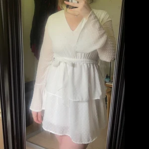 Fin klänning  - En fin klänning med vida ärmar vid handlederna som oxå har ett band runt midjan som du kan knyta till en rosett. Den har en fin v-ringning 
