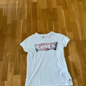 Levis t-shirt - Levis t-shirt med blommigt tryck. Välanvänd men i bra skick förutom en liten fläck som syns på ena bilden. 
