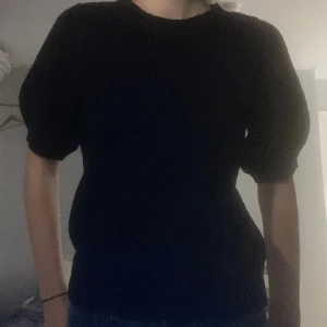 Stickad t-shirt - En svart, stickad, kortärmad tröja med puffiga axlar från Vero Moda. Nypris ca 350kr. Läs gärna min profil innan köp, kontakta eller buda istället för att köpa direkt❤️