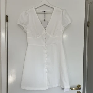 Söt klänning - Klänning med knappar från Nelly. Helt ny med prislapp kvar. Storlek 38🤍