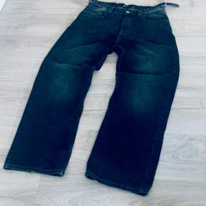 Ett par svarta jeansbyxor från Vicinity i storlek L (32L). Byxorna har en bred passform och är tillverkade i jeansmaterial. Byxorna har en midjejustering. Är använda ett par gånger men är som nya med minimalt slit nertill (bild 3). Org. Pris 1000kr