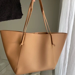 Stor väska - Nyskick, använd 1-2 gånger. Brun/orange i färgen. Har ett litet märke på sidan