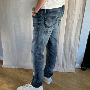 Jack and Jones Slim Glenn - Säljer ett par Jack and Jones jeans som är otroligt bra skick men har slitningar som är med i designen. Sitter skönt men är något för stora för mig. Skick 9,5/10. Hör av er vid minsta fundering! Pris kan diskuteras vid snabb affär.