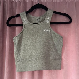 Träningstopp från Stronger - En grå lite längre tränings topp/linne ifrån Stronger! Säljer då den ej kommer till användning. Använd väldigt få gånger 🥰 pris kan diskuteras 