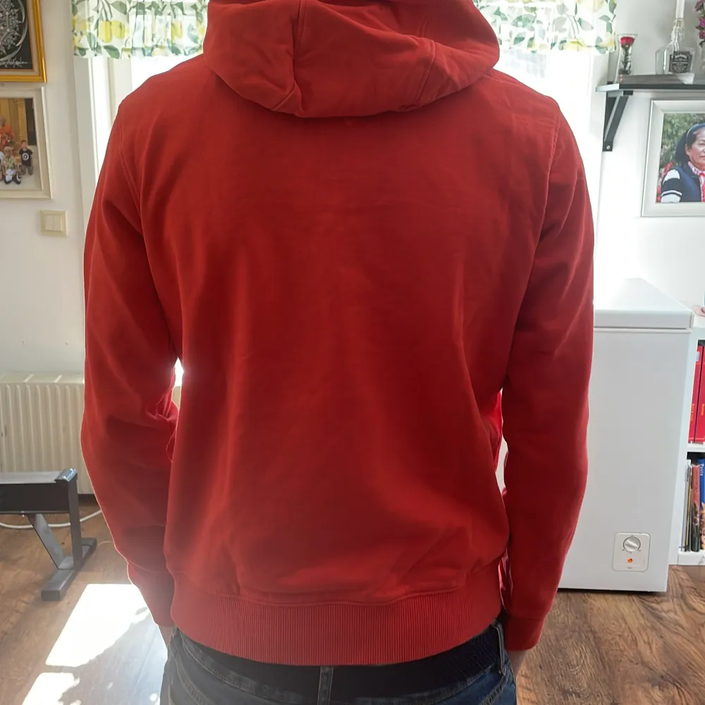 En orange/röd tommy hilfiger tjocktröja som har blivit lite liten för mig, det finns en liten fläck (finns bild). Hoodies.