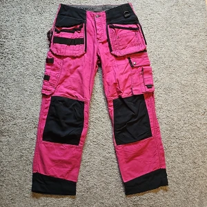 Björnkläder Rosa arbetsbyxa - Rosa arbetsbyxor från Björnkläder. Väldigt sparsamt använda. Många fickor för verktyg. Står storlek 42 i byxorna men för små för mig som har storlek 40. Skulle mer gissa på storlek 36-38