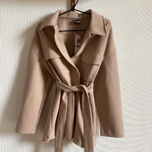 Vårjacka med knytskärp - Oanvänd jacka från Gina Tricot som jag köpte förra året    