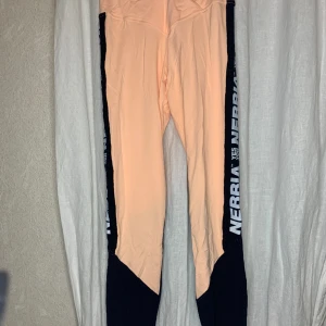 Nebbia träningstights  - Säljer ett par tights från nebbia jag endast använt 1 gång då färgen ”diddnt flatter me” så efter den gången fick den bo i garderoben Färgen heter ”salamon”, dem är high waisted med en liten mesh detalj (se bild 3) och ”scrunch” på rumpan🥰