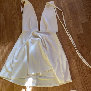 Vit klänning - Vit halterneck klänning med snörning! Från pretty little thing! Gått upp ca 2 cm i en söm vid midjan!