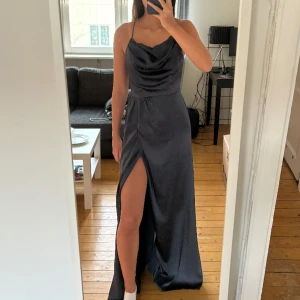 Balklänning - Nu är det dags för mig att sälja min balklänning !! En marinblå lång balklänning från ASOS i storlek XS 🥰 Kors i ryggen och slit i benet! Perfekt lång med klackar till ☺️☺️ tyget fram är perfekt för att slippa ha en BH under!!