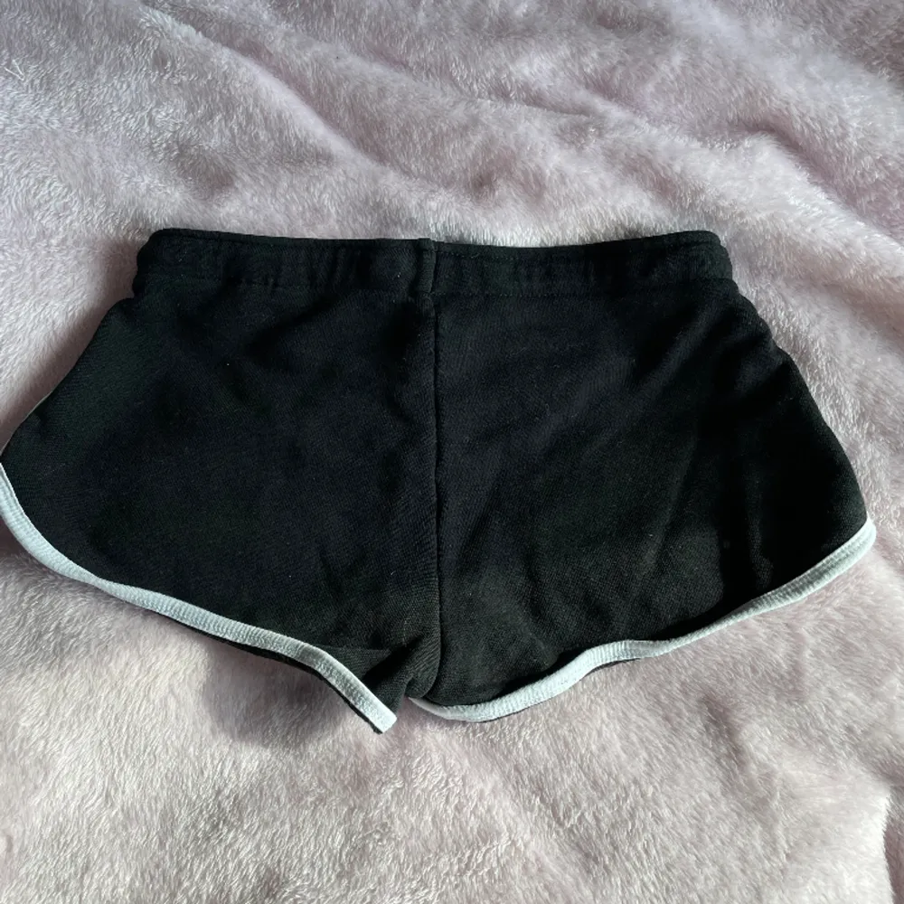 Svarta short med vita kanter, köpt på New Yorker. Inga defekter och säljs då de är för små. Storlek XS. Shorts.