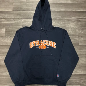 Champion Syrascue Hoodie - Snygg champion Hoodie i storlek S! Bara att skriva om du undrar över något🙏  Finns en liten vit fläck vid axeln som man kan se i bilden🙏