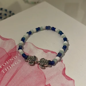 Hemmagjort armband - Ett hemmagjort armband och just denna finns i fyra olika storlekar och du bestämmer själv om du vill köpa en eller flera! Det är två sköldpaddor på med mörkare blå, ljusare blå och vit. 