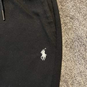 Svarta Ralph Lauren byxor som tillhör zip-up tröjan. 