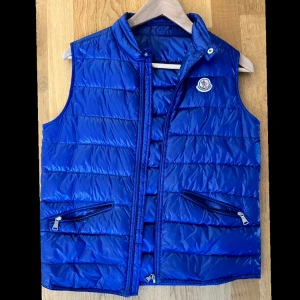  Moncler väst. - En i princip oanvänd Moncler väst som är köpt på NK, kvitto finns. Storlek 164.