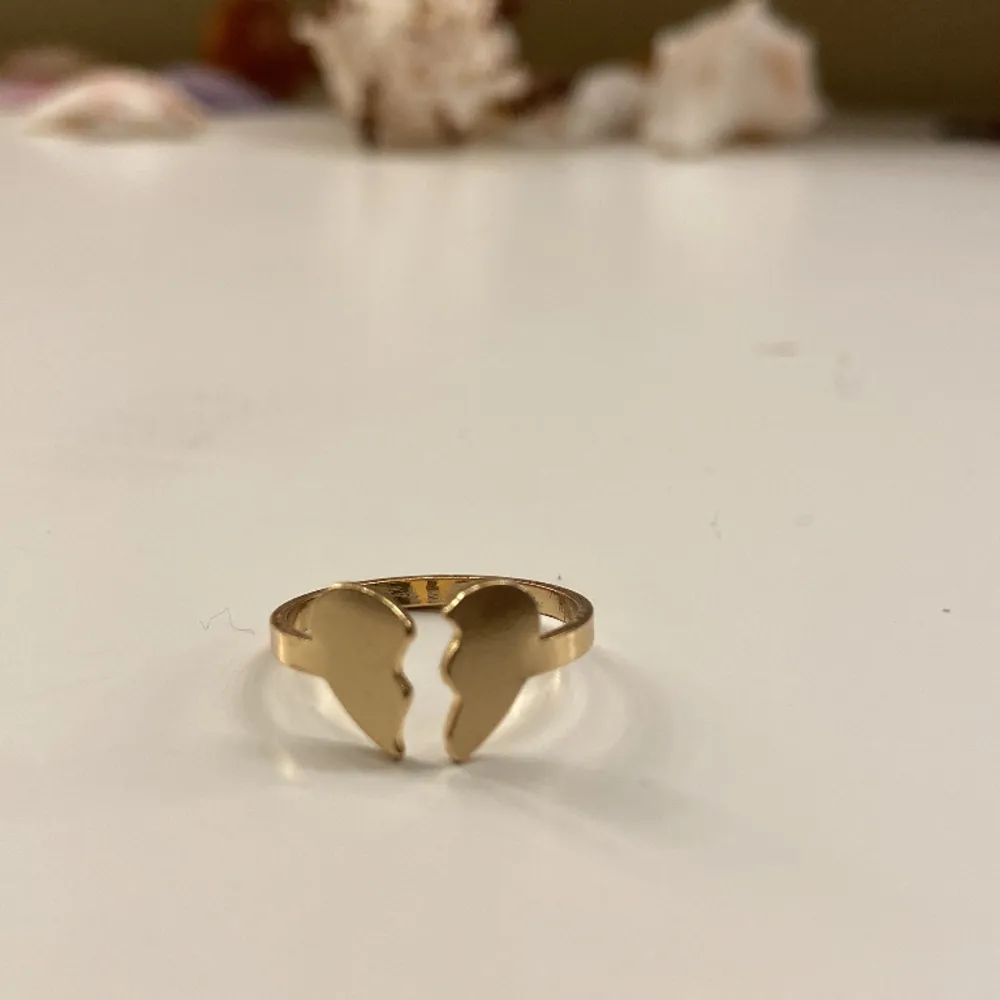 Säljer denna guldiga ring med ett krossat hjärta från okänt märke. Jag fick den av min mamma för någon dag sedan, och jag säljer för att den inte passade till mina andra ringar. Den är i mycket bra skick. Okänt orginalpris, säljer för 30kr+frakt.. Accessoarer.