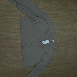 Cardigan/topp - Super fin topp/cardigan. Funkar som en fin sommartopp men även kofta då man kan knäppa upp den, aldrig använd prislappen är kvar 
