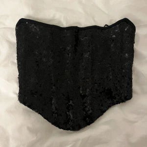 Tubtopp - Svart tubtopp/korsett med paljetter från ginatricot, använd 1 gång