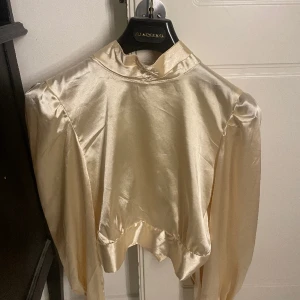 Guldig/champangefärgad blus - Strl S. Superfin blus med öppen rygg och knytning i ryggen