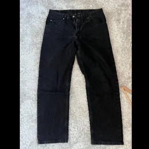 Svarta Wrangler jeans - Ett par svarta jeans från wrangler. 9/10 skick. Väldigt lika en Levis 501 kanske aningen vidare. W33 x L30 Finns att hämta i Bromma men kan också mötas upp i centrala Stockholm