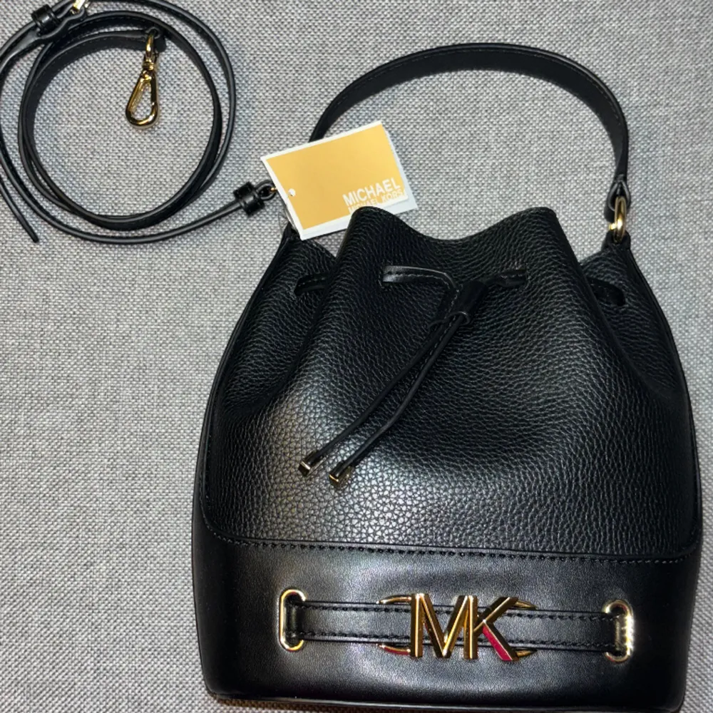 Äkta MK bucket väska oanvänt, köpte över telefon och de hade ej öppetköp. Det är gjort av kalvskinn och kommer med en längre remma och sin prislapp.  Köpt för 3700+.. Väskor.