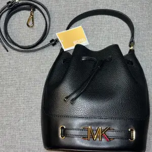 Äkta MK bucket väska oanvänt, köpte över telefon och de hade ej öppetköp. Det är gjort av kalvskinn och kommer med en längre remma och sin prislapp.  Köpt för 3700+.